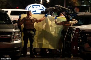 Nancy Guthrie police hold up sheet as they remove items from Range Rover after they held man in traffic stop at restaurant parking lot
