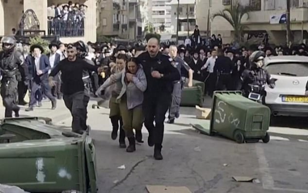 Moment two female Israeli soldiers are rescued as they are chased by 1,000 ultra-Orthodox men