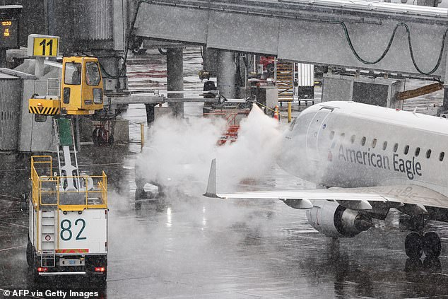 Blizzard brings travel hell to the US as 10,000 flights grind to a halt and weather correspondent struggles to stay standing: ‘This is wild!’