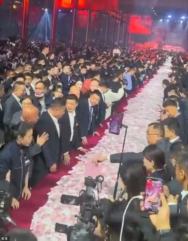Thanks boss! Chinese company piles up $26million in bonus cash at end of year party with employees staggering off with as much as they can carry