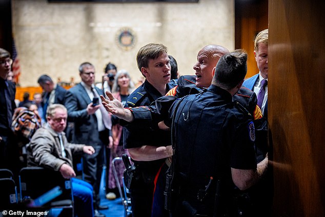 Screaming ex-Marine who heckled US Senator and was ejected from congressional hearing BROKE HIS ARM during violent brawl