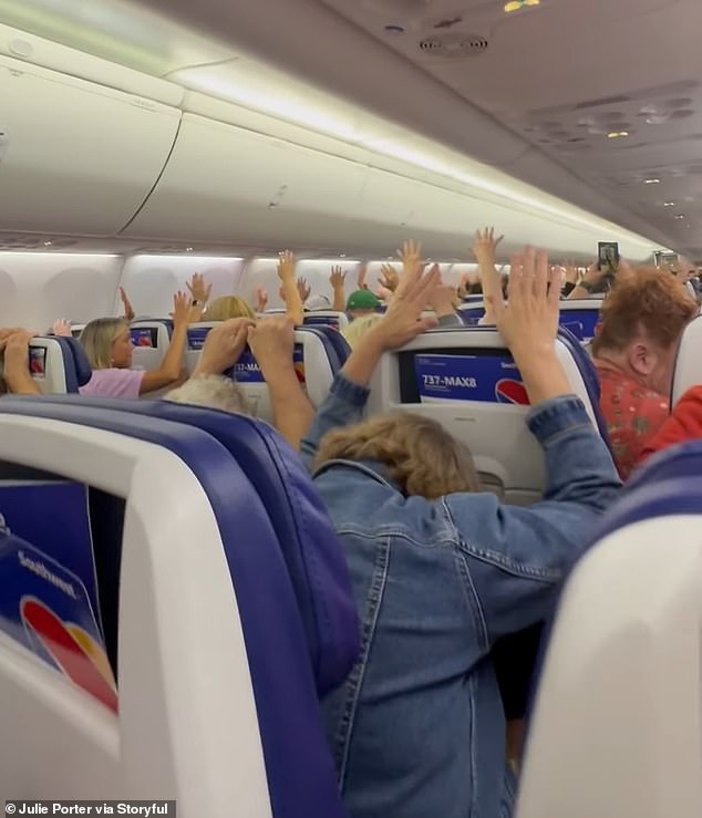 Moment terrified passengers hold their hands up as armed officers deplane travelers after alarm tone triggers threat alert