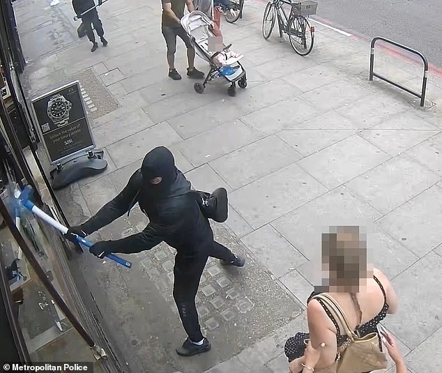 Moment sledgehammer-wielding thugs smash way into luxury store before fleeing with £60,000 of watches and jewellery