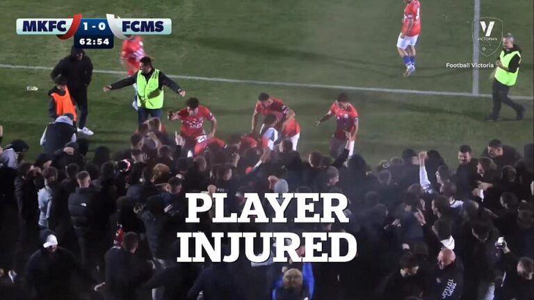 Footy player injured in crowd surge chaos that saw a fence collapse on top of him