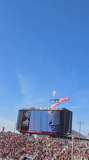 Horrifying moment skydiver is blown into scoreboard during festivities before college football game