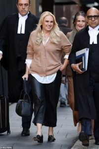 Rebel Wilson beams as she turns up at court – before she has the smile wiped from her face after she was accused of tampering with vital evidence