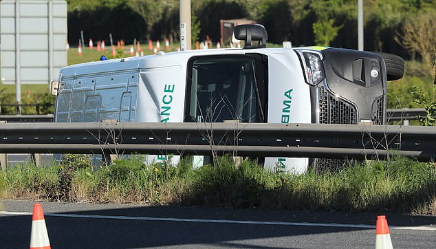 Four people rushed to hospital after ambulance flips on its side in crash with car and lorry