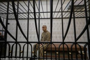 Moment cousin of fallen Syrian dictator Assad is paraded in courtroom cage as he goes on trial accused of mass shootings and torturing children