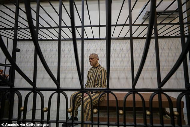 Moment cousin of fallen Syrian dictator Assad is paraded in courtroom cage as he goes on trial accused of mass shootings and torturing children