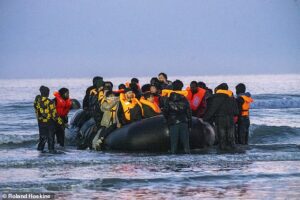 Migrants pile into death-trap dinghies in bid to traverse the Channel as French police watch on and do nothing AGAIN – with number of small boat crossings set to hit 200,000