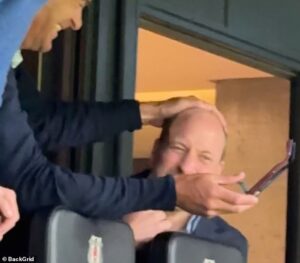 Letting his heir down! Prince William gets a playful pat on the head from old pal Edward van Cutsem as they lark about on rare boys’ night out at the football