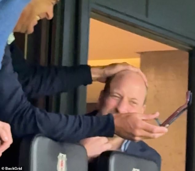 Letting his heir down! Prince William gets a playful pat on the head from old pal Edward van Cutsem as they lark about on rare boys’ night out at the football