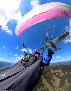 Terrifying moment plane crashes into paraglider, sending her spiralling through the air before emergency parachute saves her