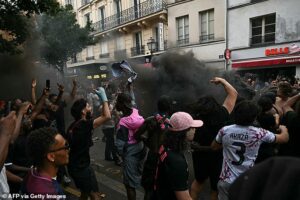 PSG fans clash with riot police on streets of Paris as night of chaos looms after Champions League final victory over Arsenal
