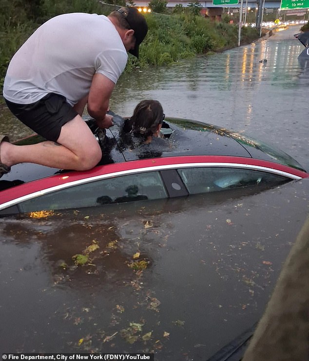 Incredible moment off-duty firefighter breaks woman free from car after she became totally submerged in water during terrifying flash flood