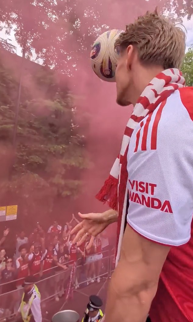 Moment Arsenal star Martin Odegaard hits police officer on head with football from victory parade bus