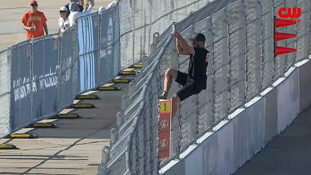 Terrifying moment NASCAR fan risks life by hopping fence to talk to driver on the track… before being arrested by federal agents