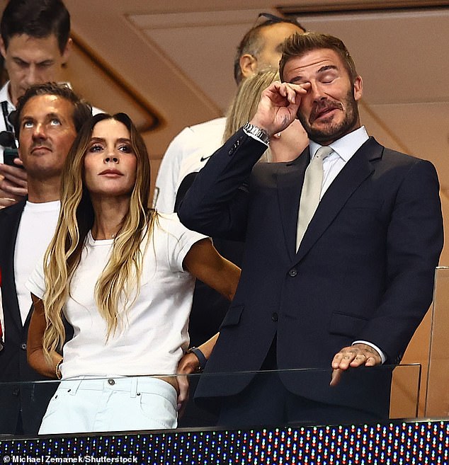David Beckham wipes away his nerves as he watches England take on Argentina in tense first half with wife Victoria and family