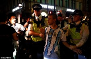 Moment Tiktok prankster wearing Argentina shirt has to be rescued by police from baying mob of England supporters in Piccadilly Circus as World Cup violence spreads across country