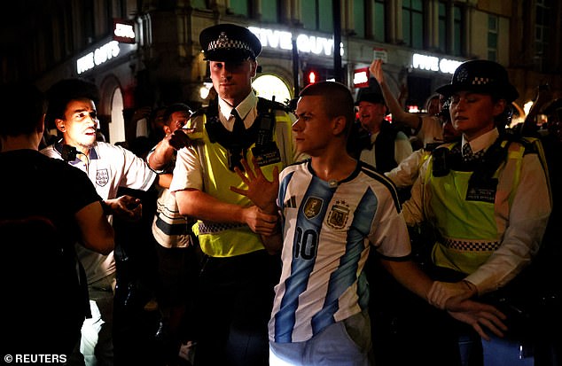 Moment Tiktok prankster wearing Argentina shirt has to be rescued by police from baying mob of England supporters in Piccadilly Circus as World Cup violence spreads across country