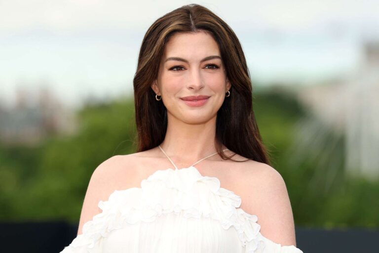 Pregnant Anne Hathaway Cradles Her Baby Bump in Flowy White Dress During “The Odyssey” Photocall in London
