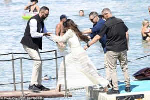 Achilles’ heels! US ambassador to Greece Kimberly Guilfoyle almost totters into the sea as she arrives at ‘gay mecca’ in SIX INCH platforms