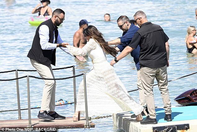 Achilles’ heels! US ambassador to Greece Kimberly Guilfoyle almost totters into the sea as she arrives at ‘gay mecca’ in SIX INCH platforms
